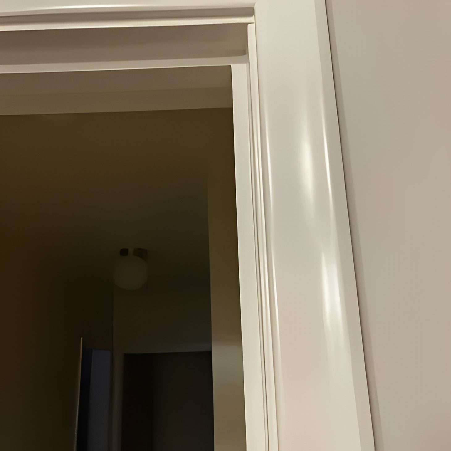 b4edc7b7-e5bd-4d92-86c5-6bb2457dee22 A door way with white walls and a light fixture.